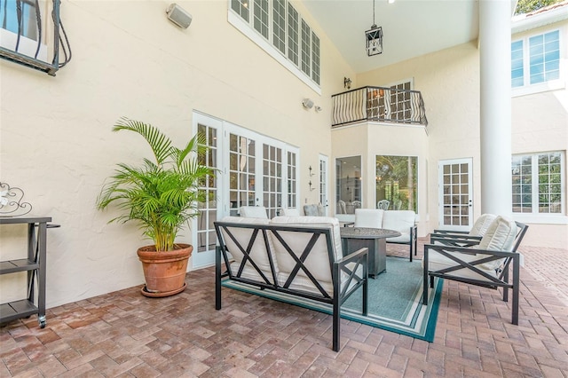 view of patio / terrace featuring a balcony and an outdoor living space with a fire pit