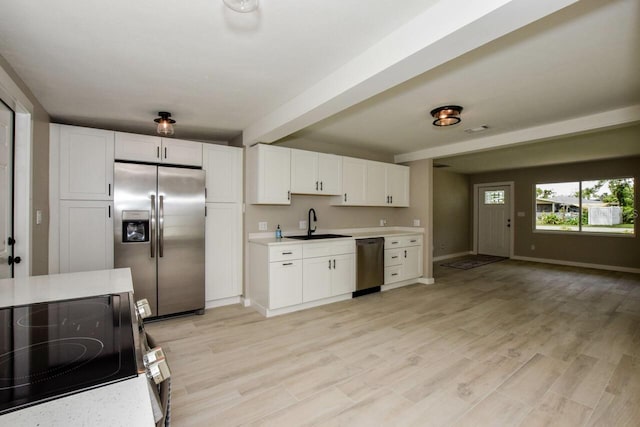 kitchen with white cabinets, stainless steel appliances, light hardwood / wood-style flooring, and sink