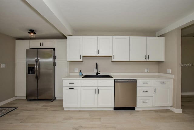 kitchen with sink, white cabinets, stainless steel appliances, and light hardwood / wood-style floors