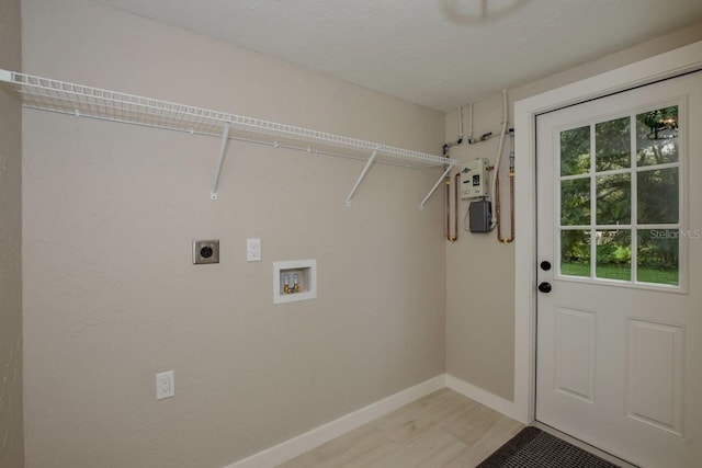 washroom with electric dryer hookup, hookup for a washing machine, and light hardwood / wood-style flooring