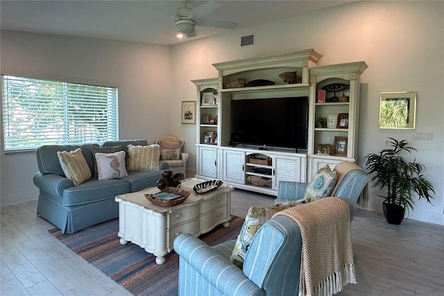 living room featuring hardwood / wood-style floors and ceiling fan