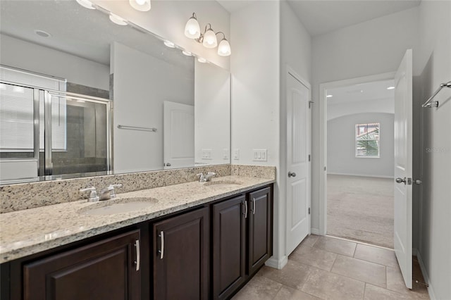 bathroom featuring tile patterned flooring, a shower with door, and vanity