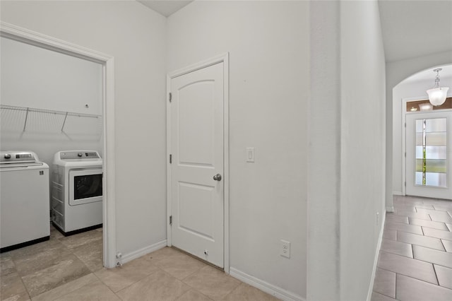 clothes washing area featuring light tile patterned flooring and separate washer and dryer