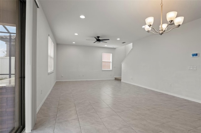 empty room with ceiling fan with notable chandelier and light tile patterned floors