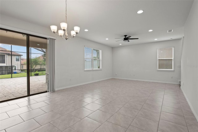 tiled spare room featuring ceiling fan with notable chandelier