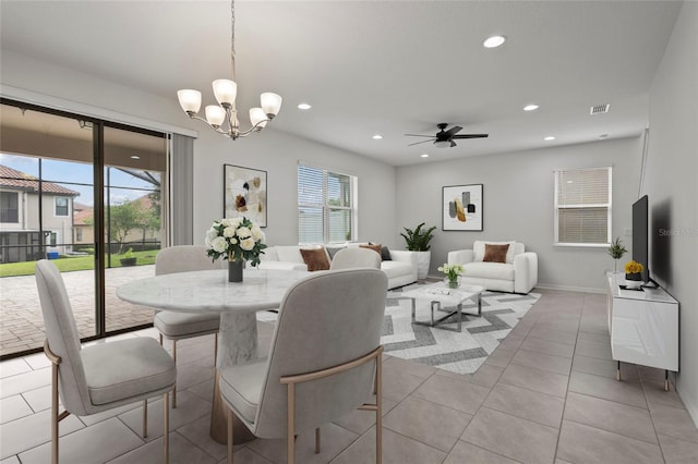 tiled dining room with ceiling fan with notable chandelier