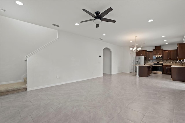 living room with light tile patterned flooring, ceiling fan with notable chandelier, and sink