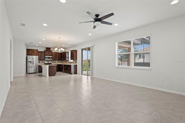 unfurnished living room featuring ceiling fan with notable chandelier and light tile patterned floors