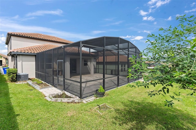 rear view of property with cooling unit, a yard, a lanai, and a patio area