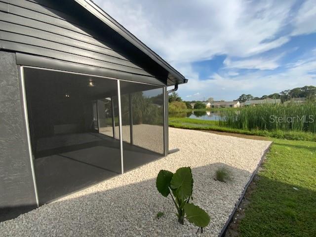 exterior space featuring a sunroom and a water view