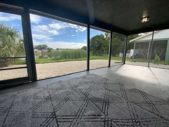 unfurnished sunroom with a water view