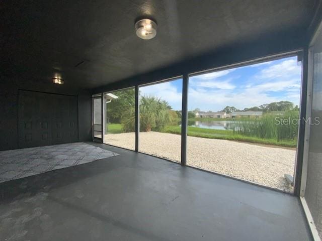 unfurnished sunroom with a water view