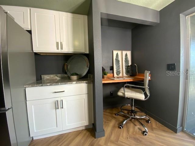 home office featuring light wood-type flooring and built in desk