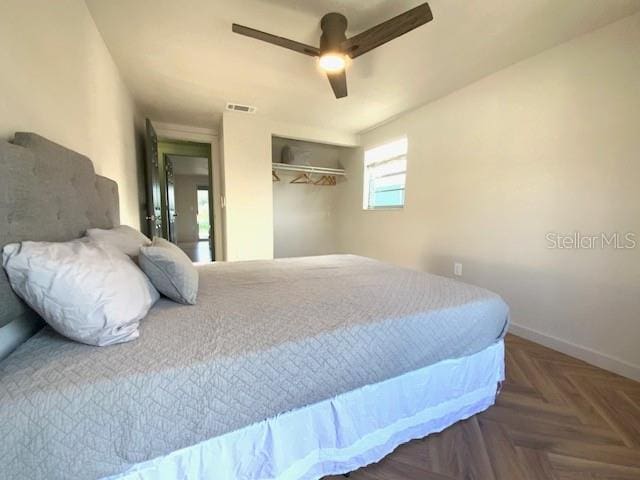 bedroom featuring a closet, ceiling fan, and dark parquet floors