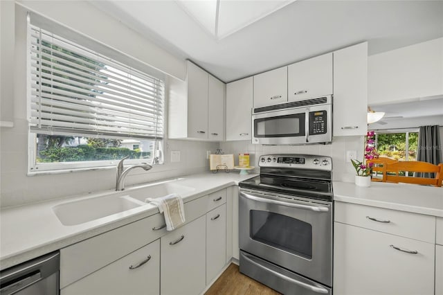3653 Bonaventure Ct, Sarasota, FL 34243 - kitchen with appliances with stainless steel finishes, a sink, light countertops, and tasteful backsplash