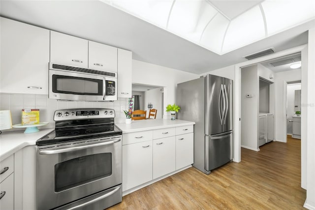 3653 Bonaventure Ct, Sarasota, FL 34243 - kitchen with stainless steel appliances, light countertops, light wood finished floors, and decorative backsplash