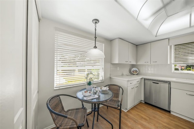 3653 Bonaventure Ct, Sarasota, FL 34243 - kitchen with dishwasher, light countertops, decorative backsplash, light wood-style floors, and plenty of natural light