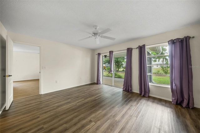 empty room with ceiling fan, a textured ceiling, and dark hardwood / wood-style floors