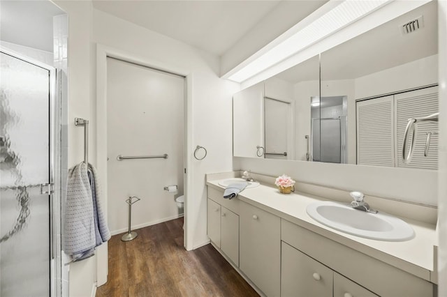 3653 Bonaventure Ct, Sarasota, FL 34243 - full bathroom featuring a shower stall, double vanity, wood finished floors, toilet, and baseboards