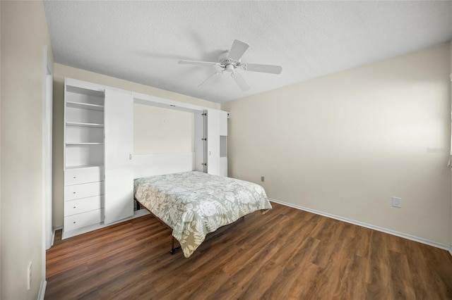 bedroom featuring dark hardwood / wood-style flooring, a textured ceiling, and ceiling fan