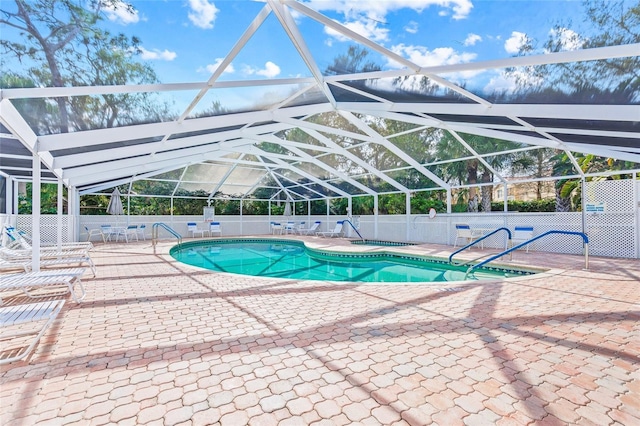 view of swimming pool featuring a patio area and a lanai