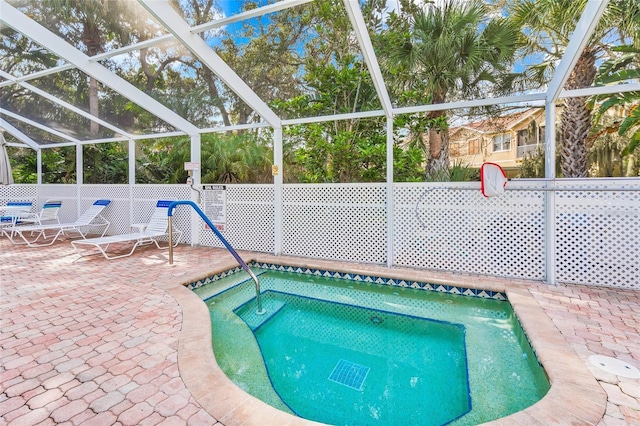 view of swimming pool featuring a patio and a lanai