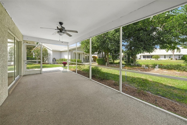 unfurnished sunroom with ceiling fan