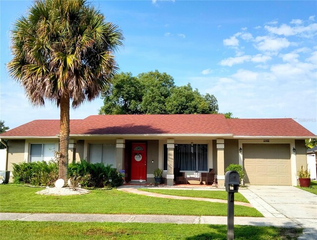 ranch-style home featuring a garage and a front lawn