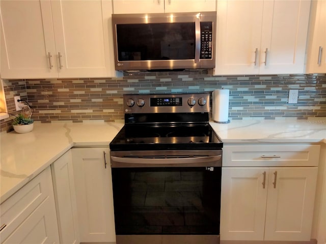 kitchen featuring tasteful backsplash, stainless steel appliances, and white cabinets