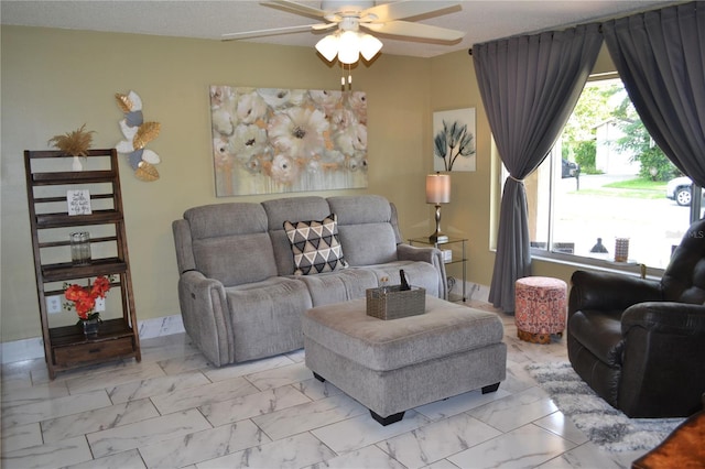 living room featuring ceiling fan and a textured ceiling