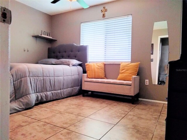 tiled bedroom featuring ceiling fan