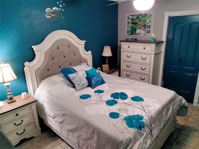 bedroom with light tile patterned floors and a closet