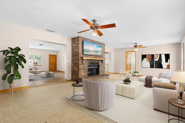 carpeted living area with visible vents, a textured ceiling, a fireplace, baseboards, and ceiling fan