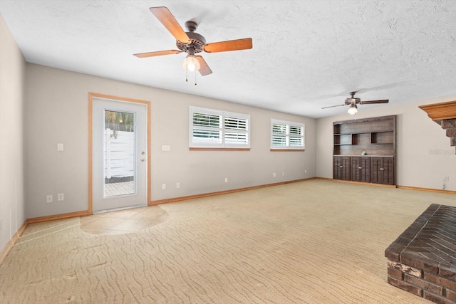 unfurnished living room featuring ceiling fan, light carpet, and a textured ceiling