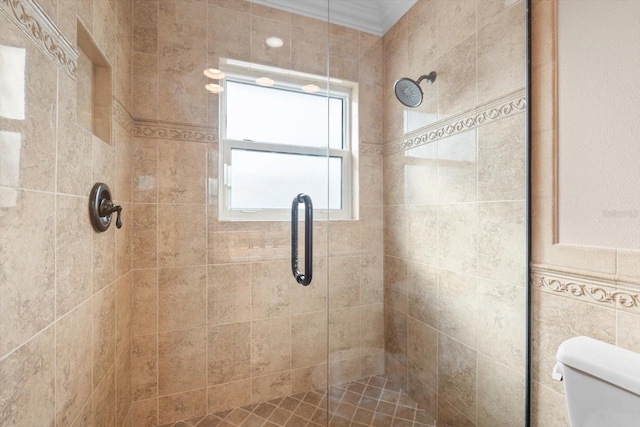 bathroom featuring crown molding, a shower with shower door, and toilet