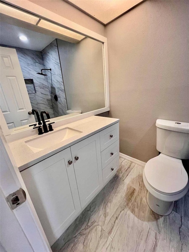 bathroom featuring vanity, toilet, and walk in shower