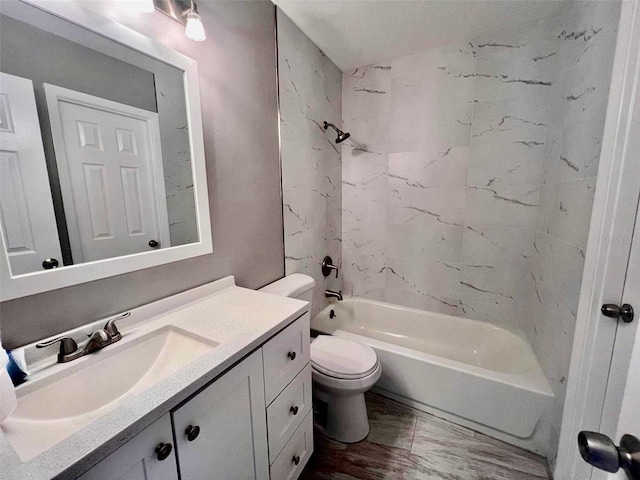 full bathroom featuring tiled shower / bath, toilet, and vanity