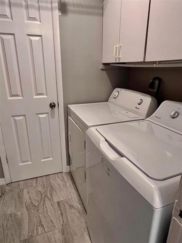 laundry room with cabinets and washer and clothes dryer