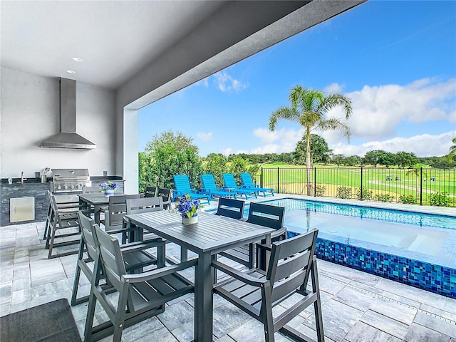 view of patio / terrace with a fenced in pool, exterior kitchen, area for grilling, and sink