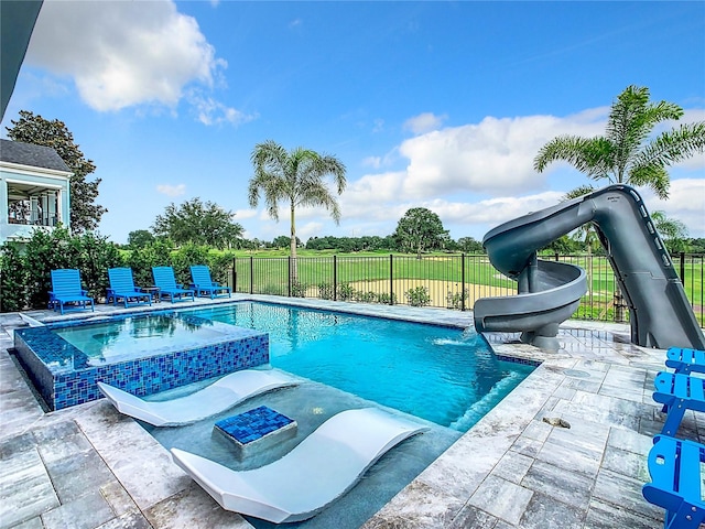 view of swimming pool featuring a water slide, an in ground hot tub, and a patio area