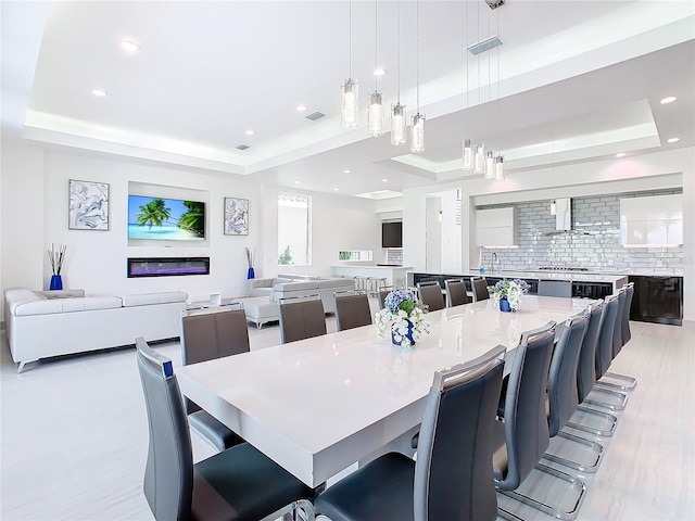 dining room with a raised ceiling and sink