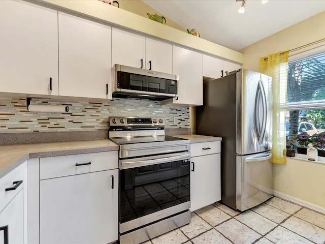 kitchen featuring appliances with stainless steel finishes, white cabinets, and backsplash