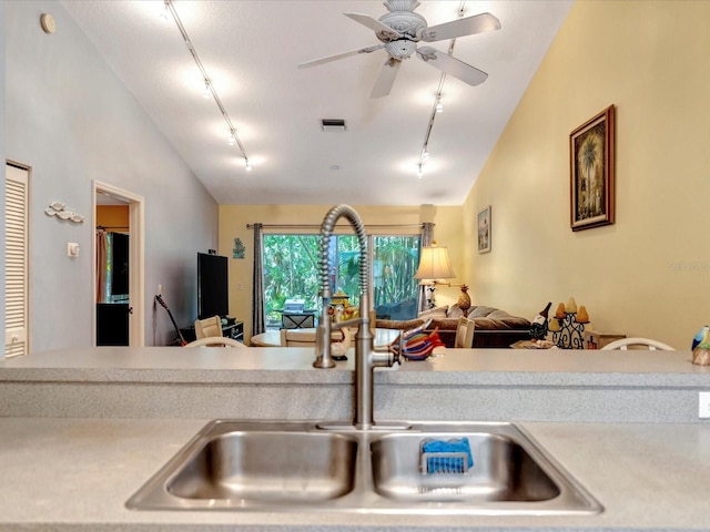 kitchen with ceiling fan, track lighting, lofted ceiling, and sink