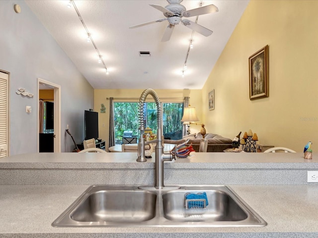 kitchen with lofted ceiling, sink, track lighting, and ceiling fan