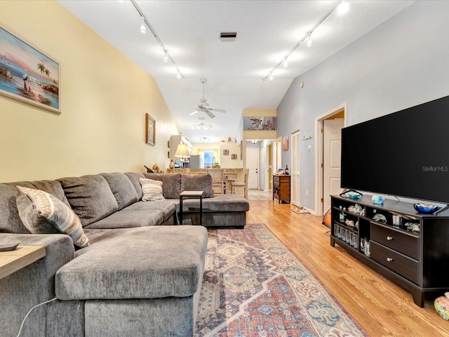 living room featuring ceiling fan, track lighting, vaulted ceiling, and light wood-type flooring