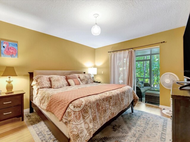 bedroom featuring light hardwood / wood-style floors and a textured ceiling