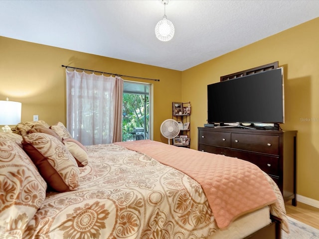 bedroom with a textured ceiling and light wood-type flooring