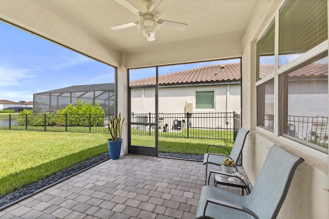 unfurnished sunroom with ceiling fan