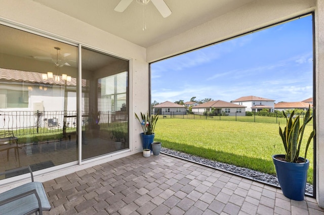 unfurnished sunroom with ceiling fan