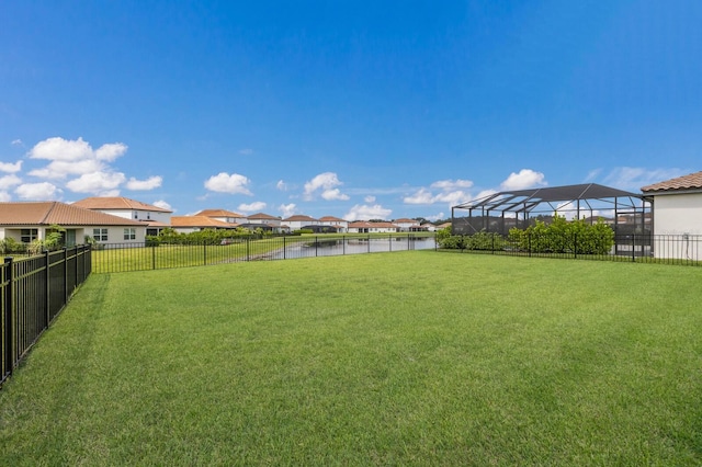 view of yard with a lanai and a water view